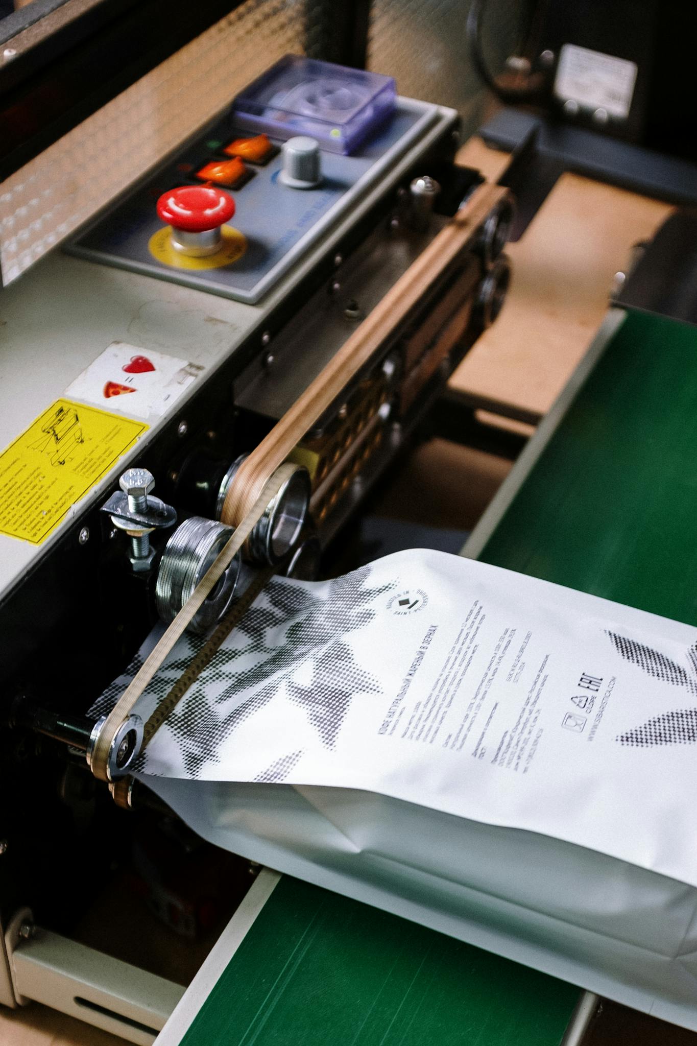 Close-up of a coffee bag being sealed by an industrial machine, showcasing manufacturing precision.