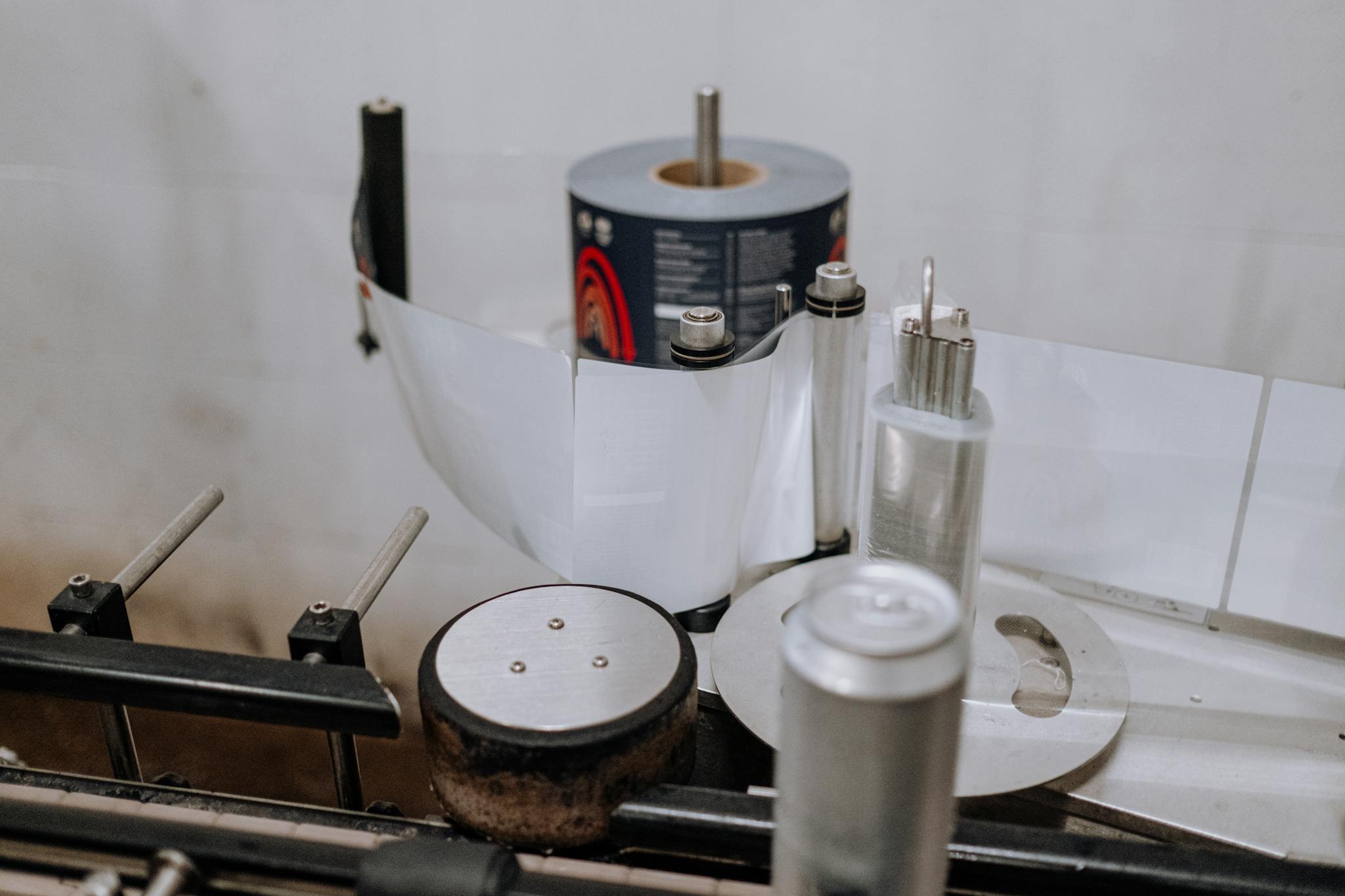 Detailed view of a brewery machinery used for labeling beer cans in an industrial setting.